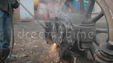 工业工人用割炬将卡车`车轮的金属部件分离<strong>开来</strong>。